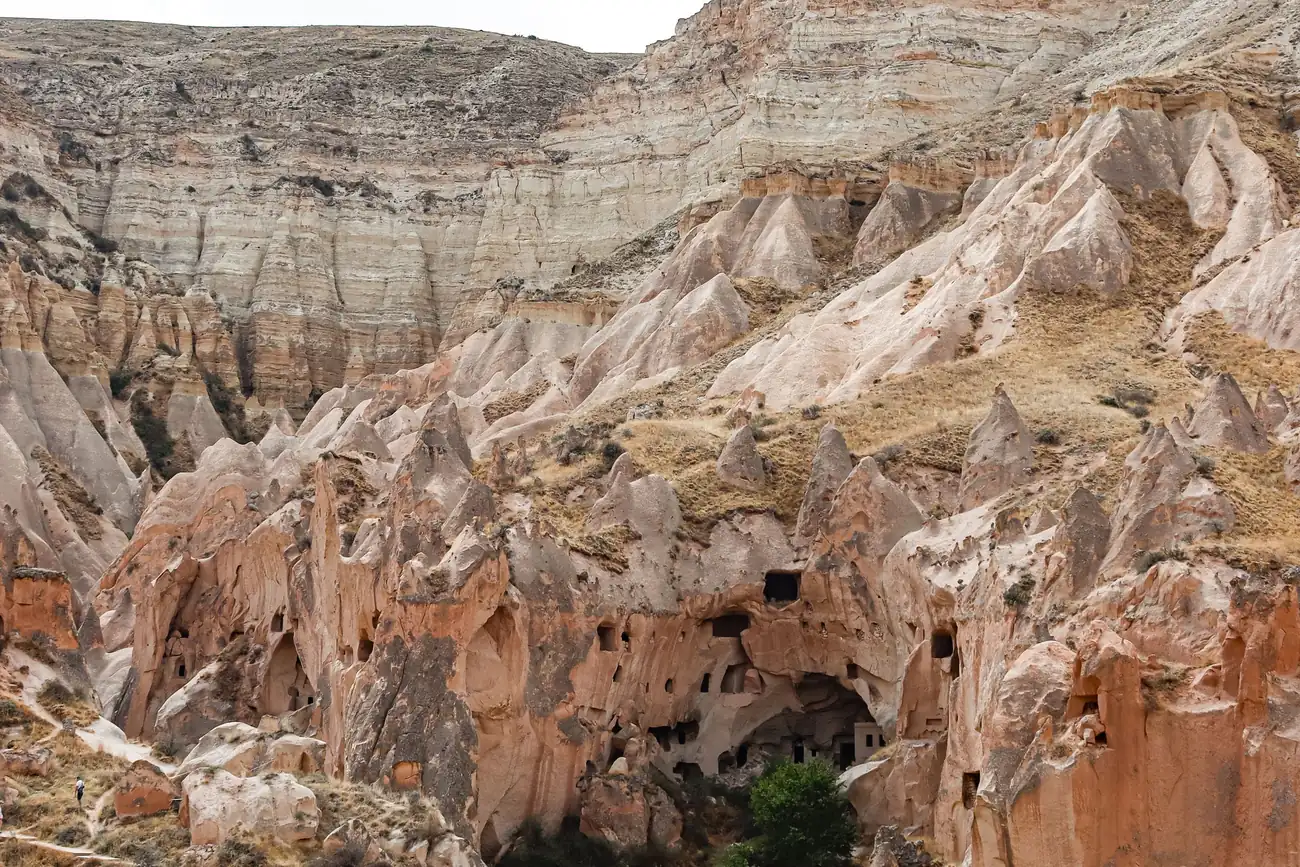 Eroded pink and cream rock walls of a Cappadocian valley